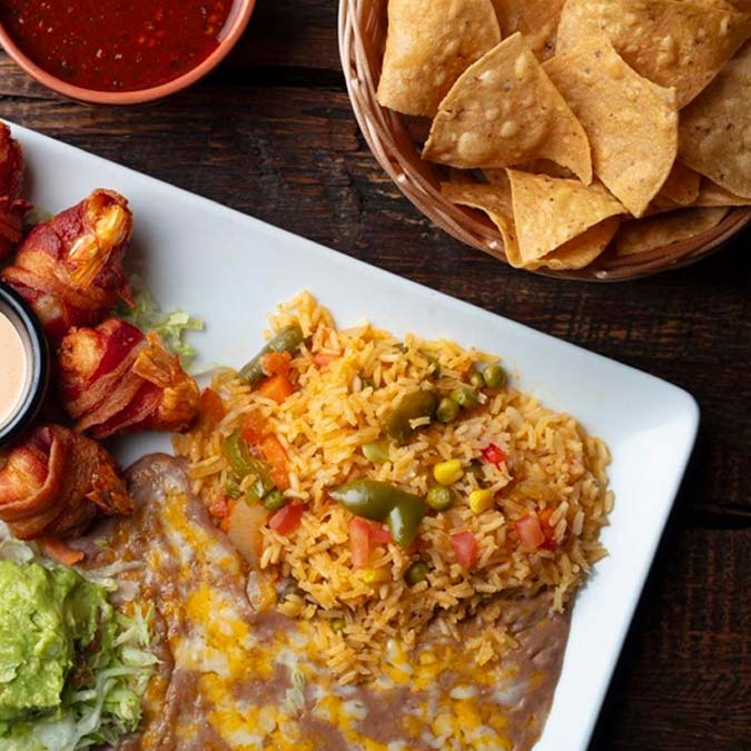 Mexican rice, refried beans, bacon-wrapped jalapeños, chips, salsa at Mi Guadalajara Restaurant.