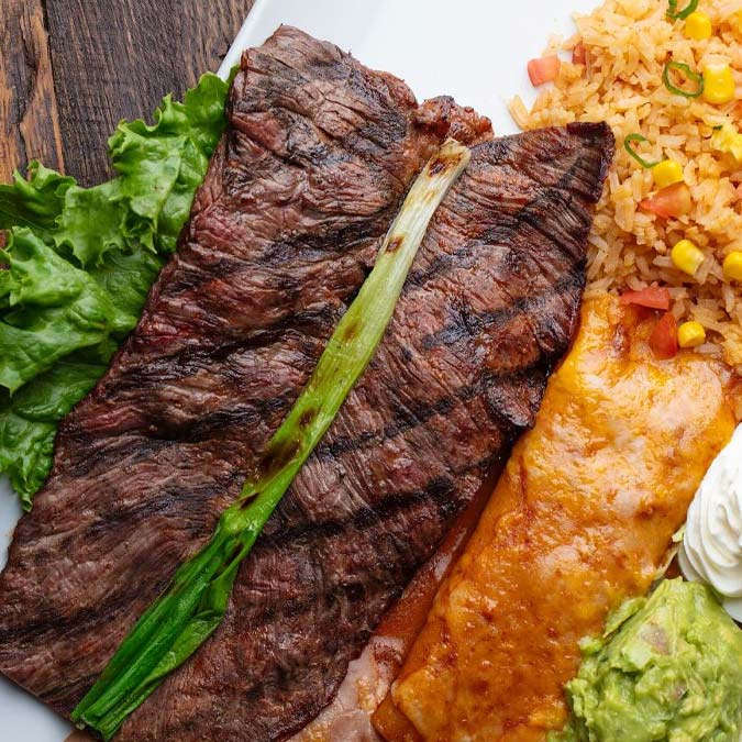 Grilled steak, lettuce, rice, enchilada, and guacamole at your favorite Mexican restaurant.