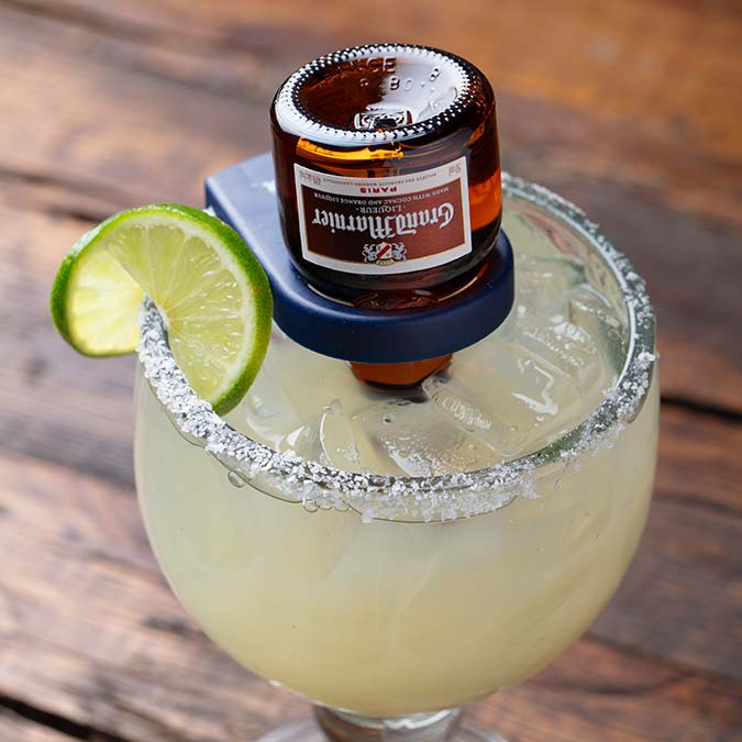 Escondido margarita with a lime wedge and mini Grand Marnier bottle upside down in the glass.