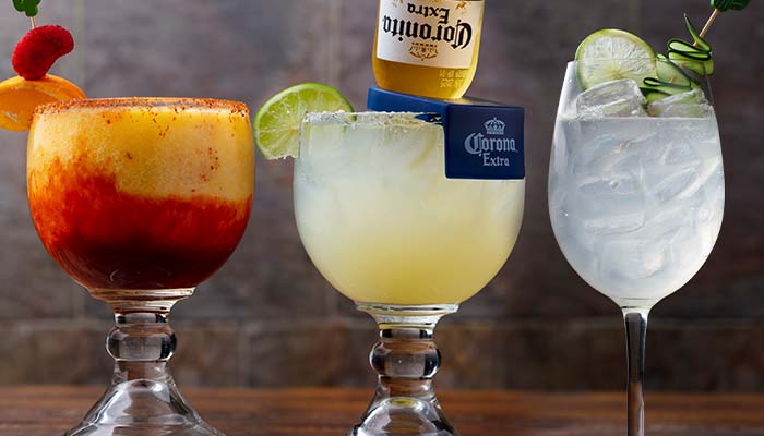 Three colorful cocktails at Mi Guadalajara Restaurant: mango, margarita with beer, and lime drink.