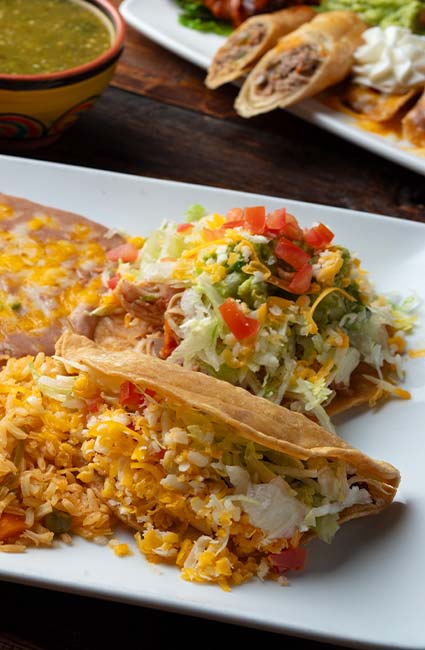 Enjoy two crispy tacos with lettuce, cheese, rice, and beans at Mi Guadalajara Restaurant.