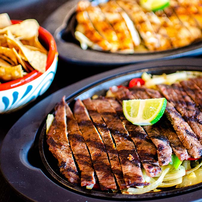 Grilled steak and chicken fajitas with lime, served with chips at our Escondido Mexican Restaurant.