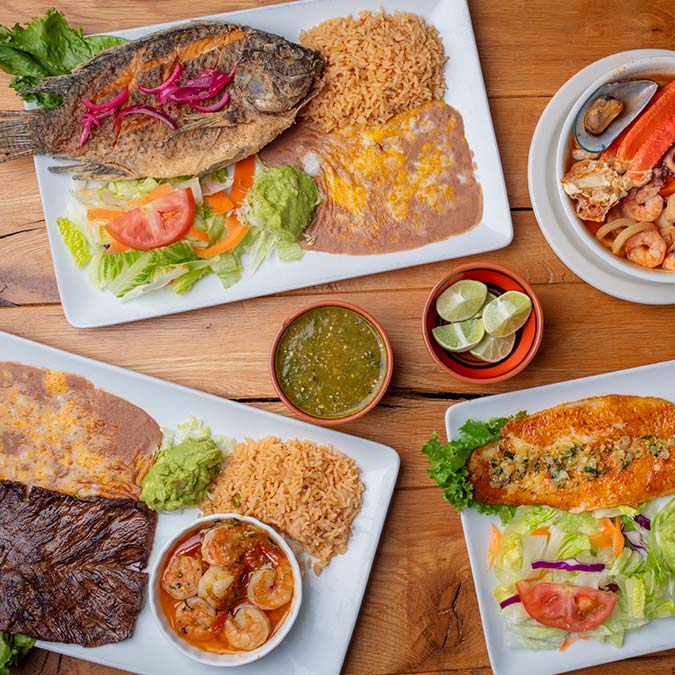 Three plates of classic Escondido Mexican Food—rice, steak, shrimp, salad, plus limes and salsa.