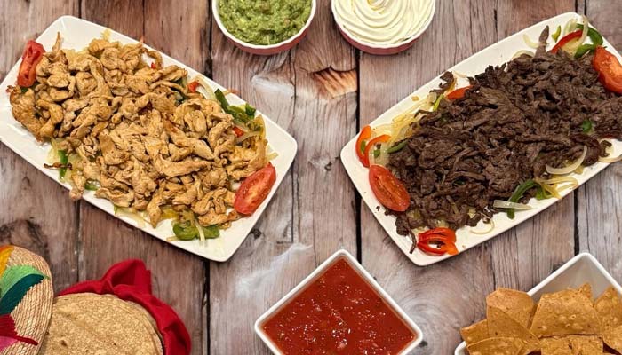 Chicken and beef fajitas, chips, tacos, salsa, and guacamole at Mi Guadalajara Restaurant.